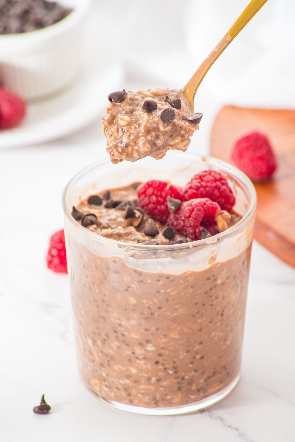 Holding up a spoonful of overnight oats with chocolate.