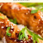 Up close shot of teriyaki salmon fillets on rice.