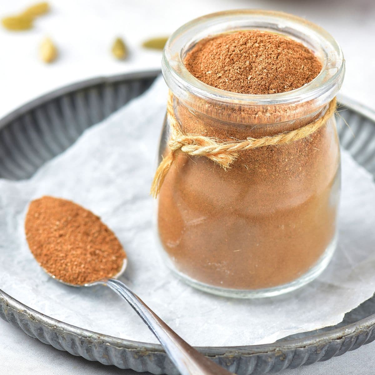 A jar of apple pie spice on parchment paper