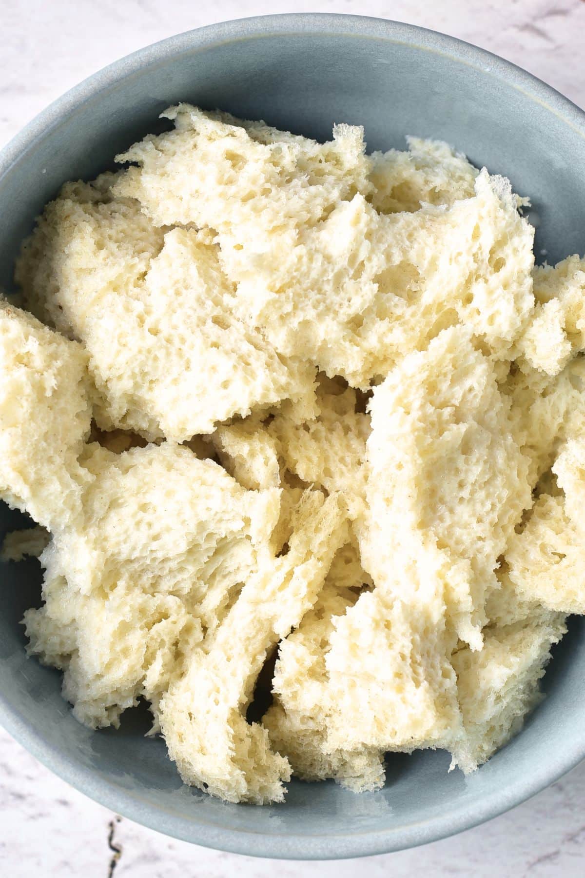 Torn bread crumbs in bowl.