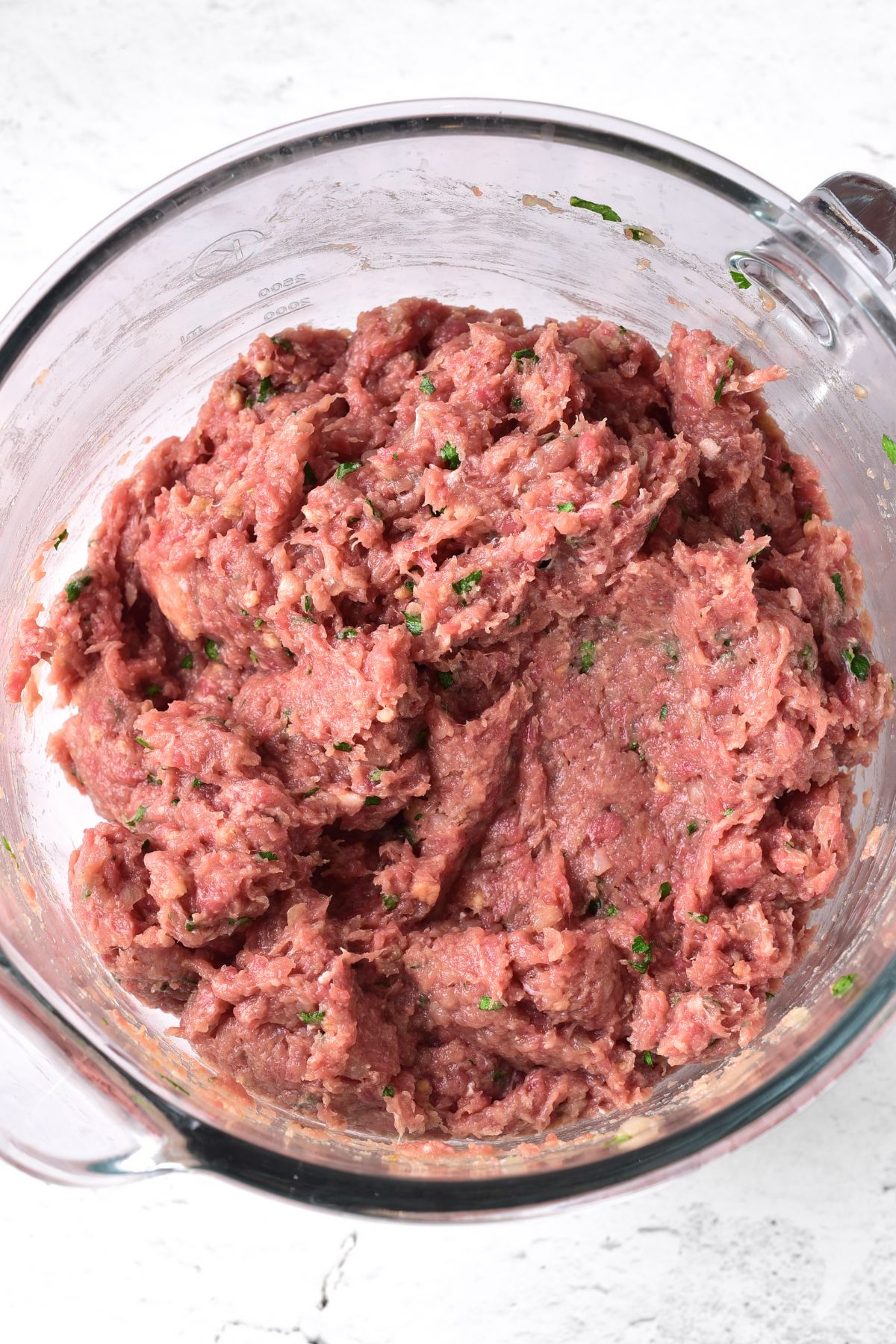 Hamburger mixture in glass bowl.