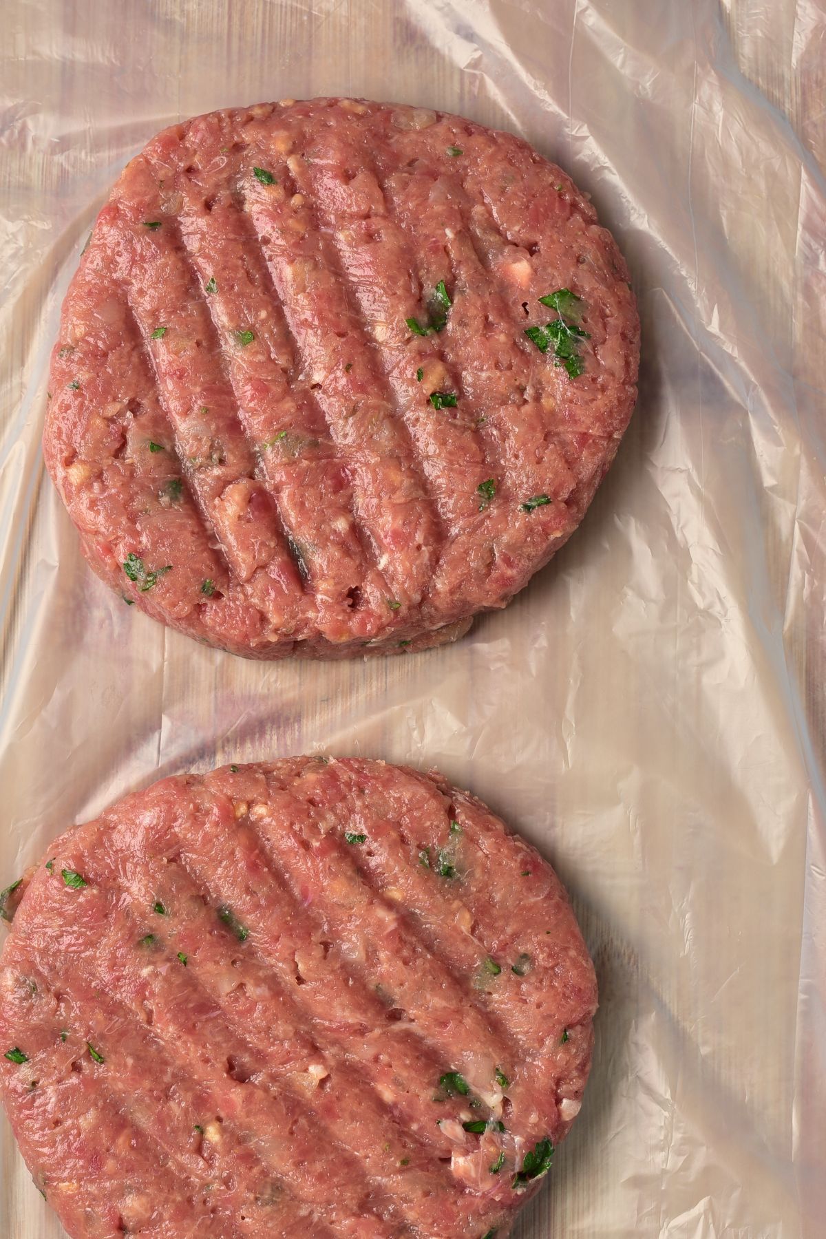 Homemade burger patties on plastic sheet.