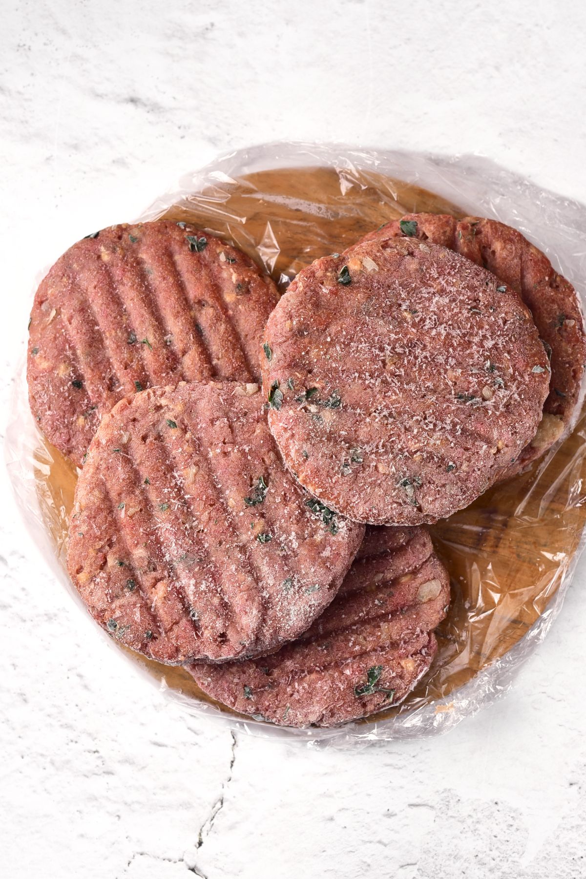 Frozen burger patties on plastic sheet