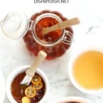 Kumquat marmalade and fresh kumquats on marble board.