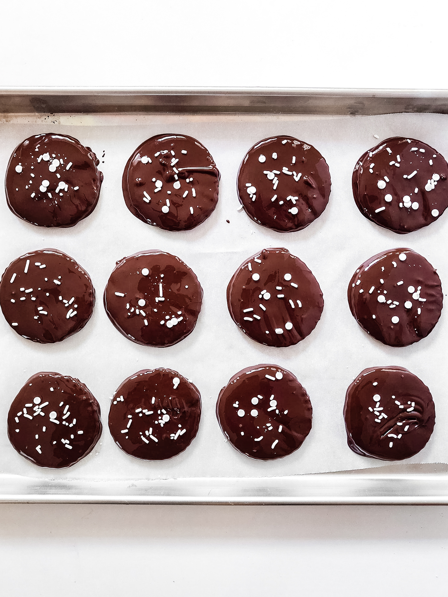 Dark chocolate peppermint patties on parchment-lined baking sheet.