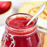 A jar of strawberry jam on wooden board