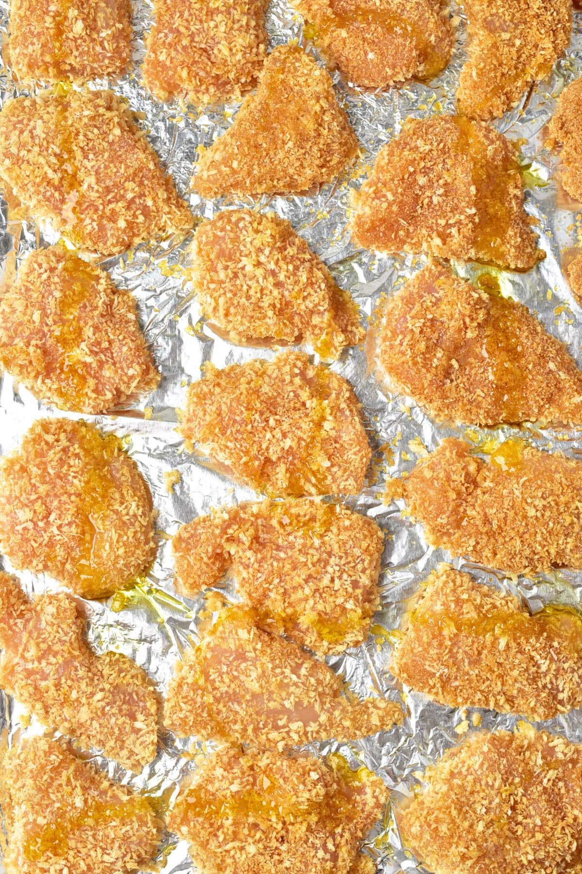 Bread crumb coated turkey pieces on aluminum foil.