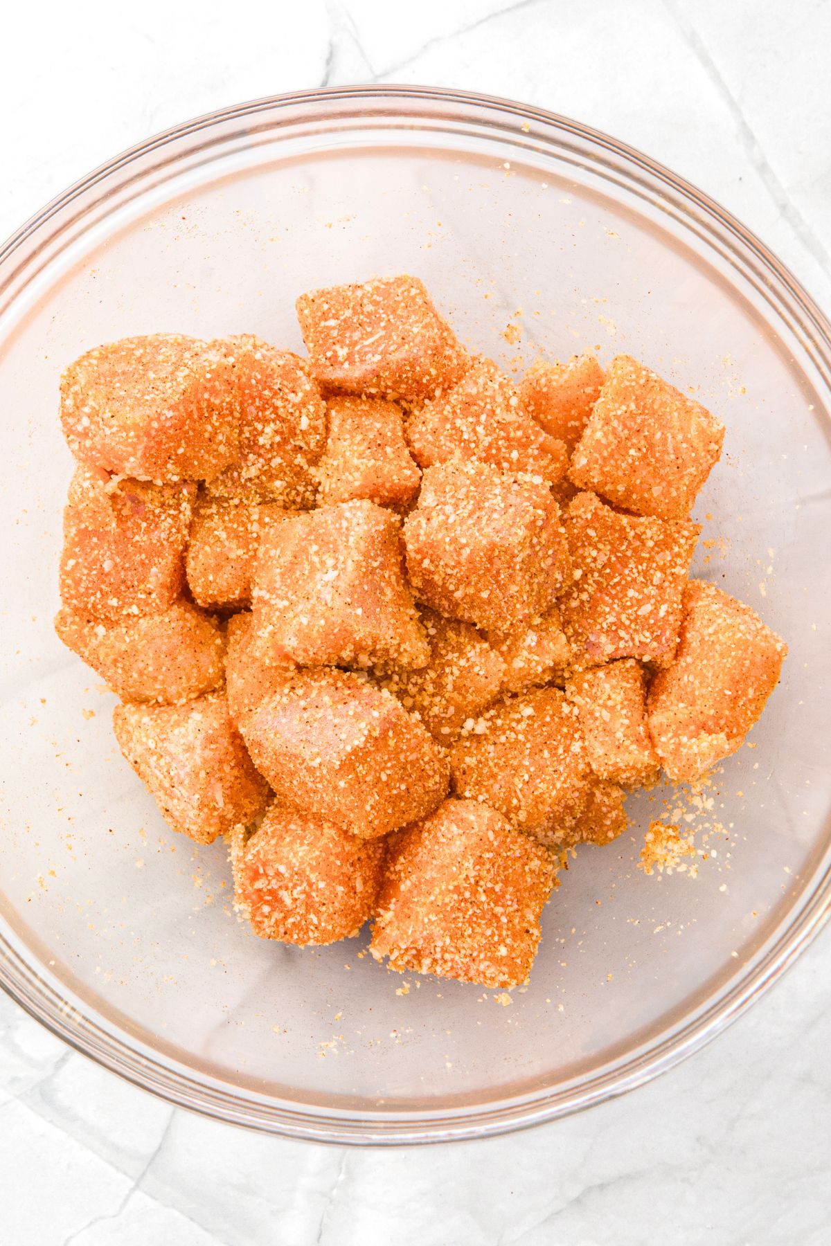 Seasoned salmon cubes in glass bowl