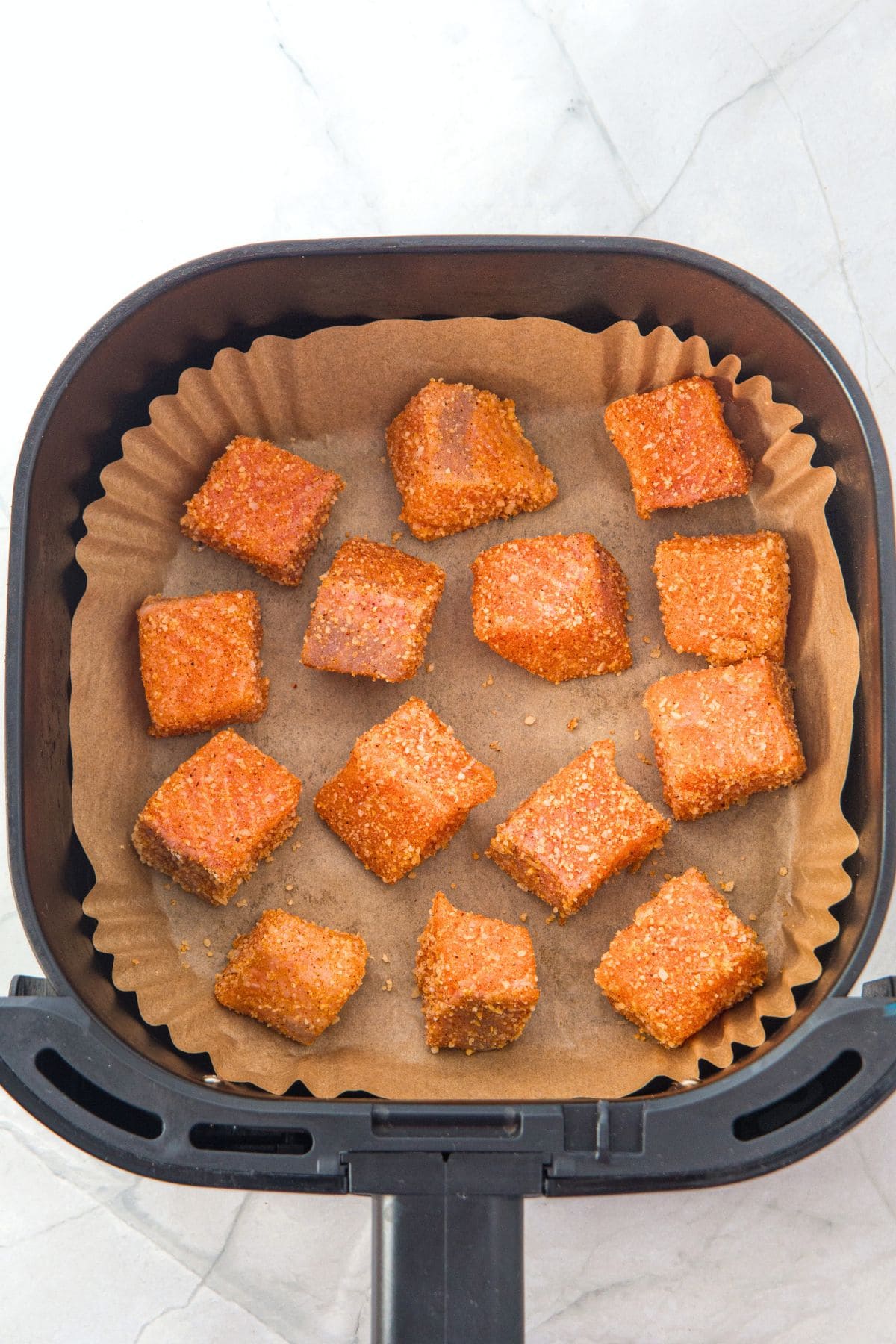 Seasoned salmon cubes in air fryer.
