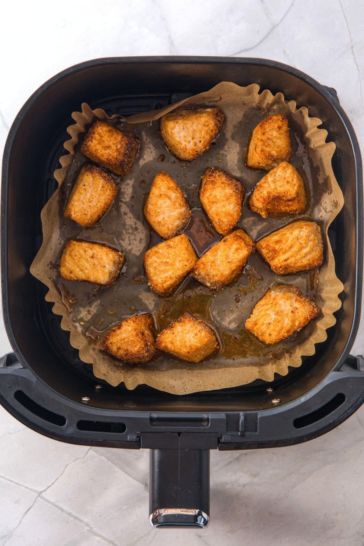 Cooked salmon bites in air fryer basket