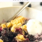 A bowl of blackberry cobbler topped with ice cream.