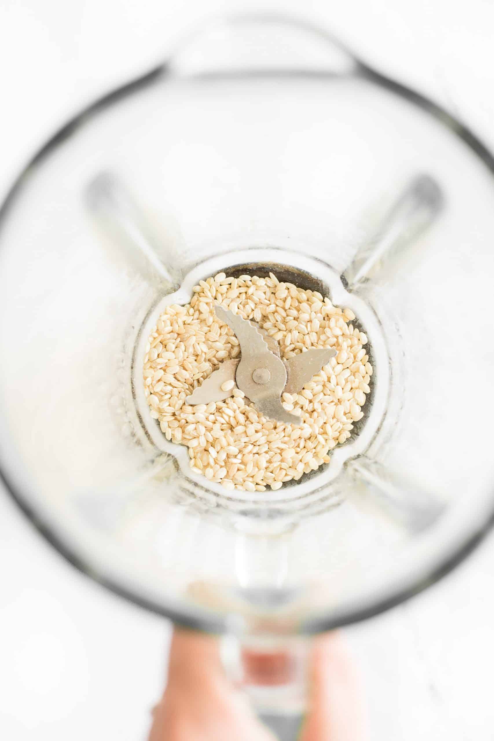 Uncooked brown rice grains in a high-speed blender before being processed.