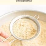 Sifting cashew flour through fine-mesh sieve