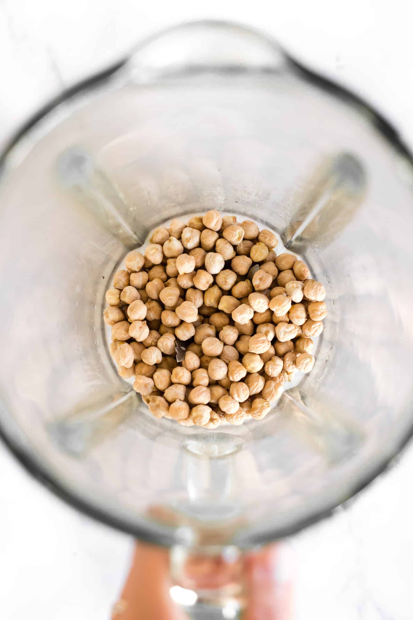 Dried chickpeas in the bowl of a high-speed blender.