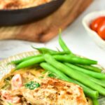 A plate of creamy Tuscan chicken with green beans