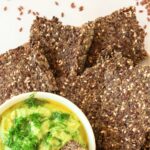 Top down view of flaxseed crackers and guacamole.