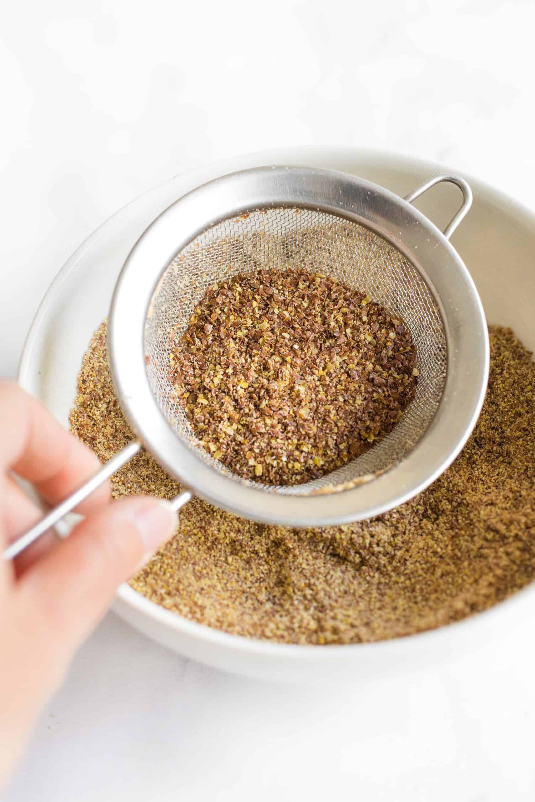 Sifting freshly ground flaxseed meal into a bowl.