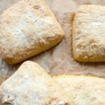 Gluten-free ciabatta buns on brown parchment paper.