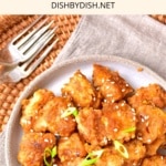 Top down view of a plate of orange chicken on a kitchen towel.