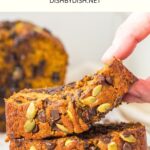 Holding up a slice of pumpkin bread from a stack.