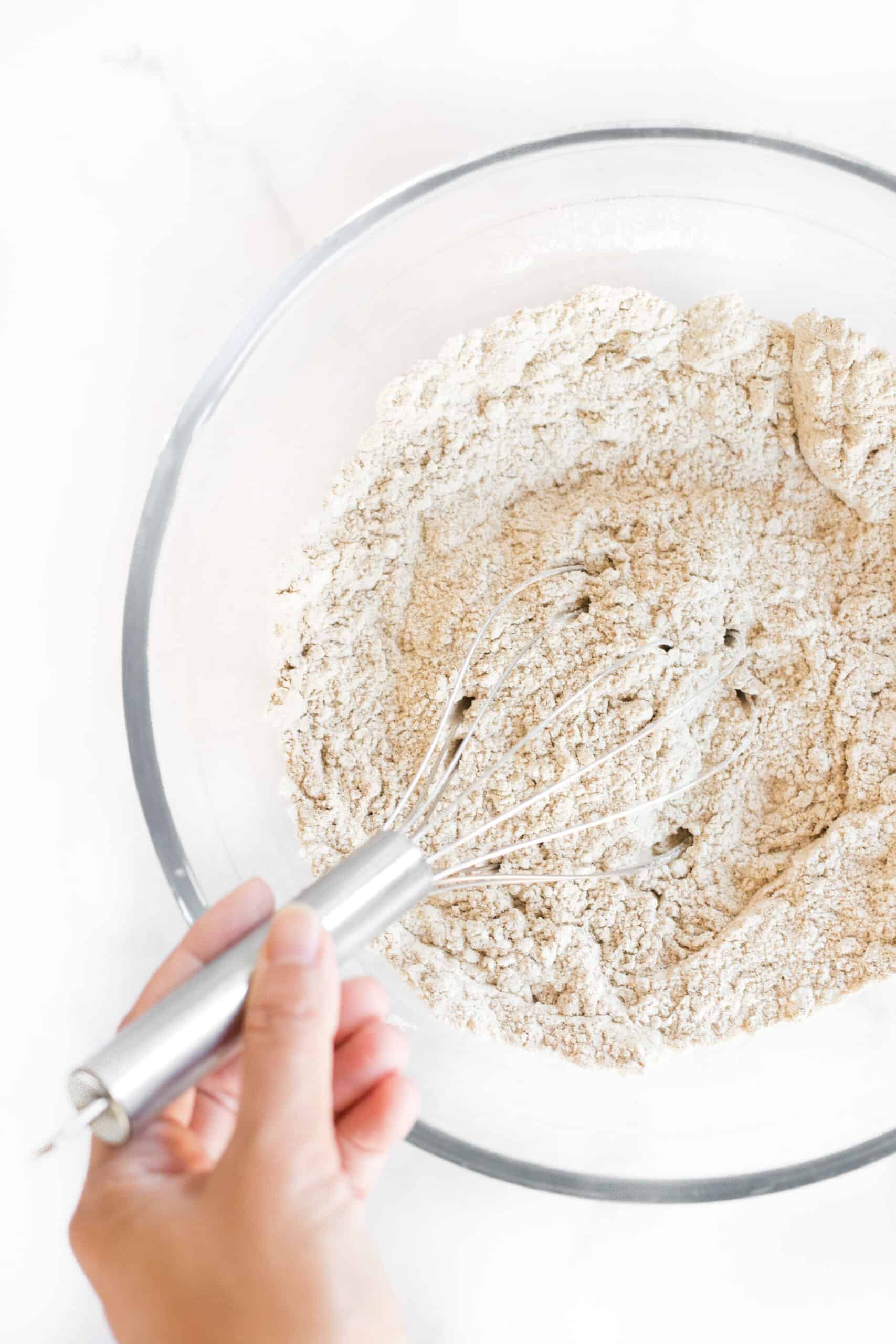 Whisking flour mixture in glass mixing bowl.