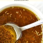 A spoon in bowl of Italian herb chicken marinade.