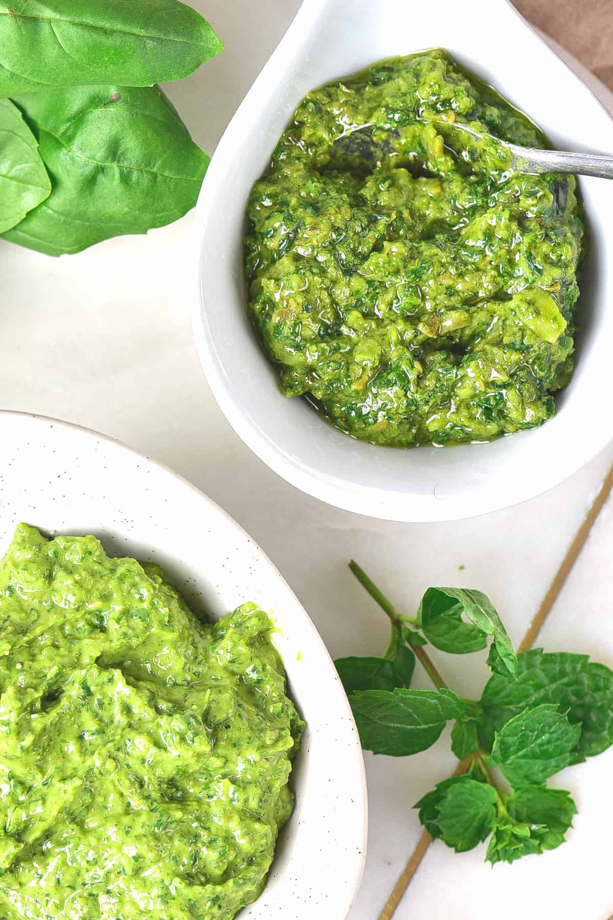 Top down view of small bowls of Italian green sauce and fresh herbs.