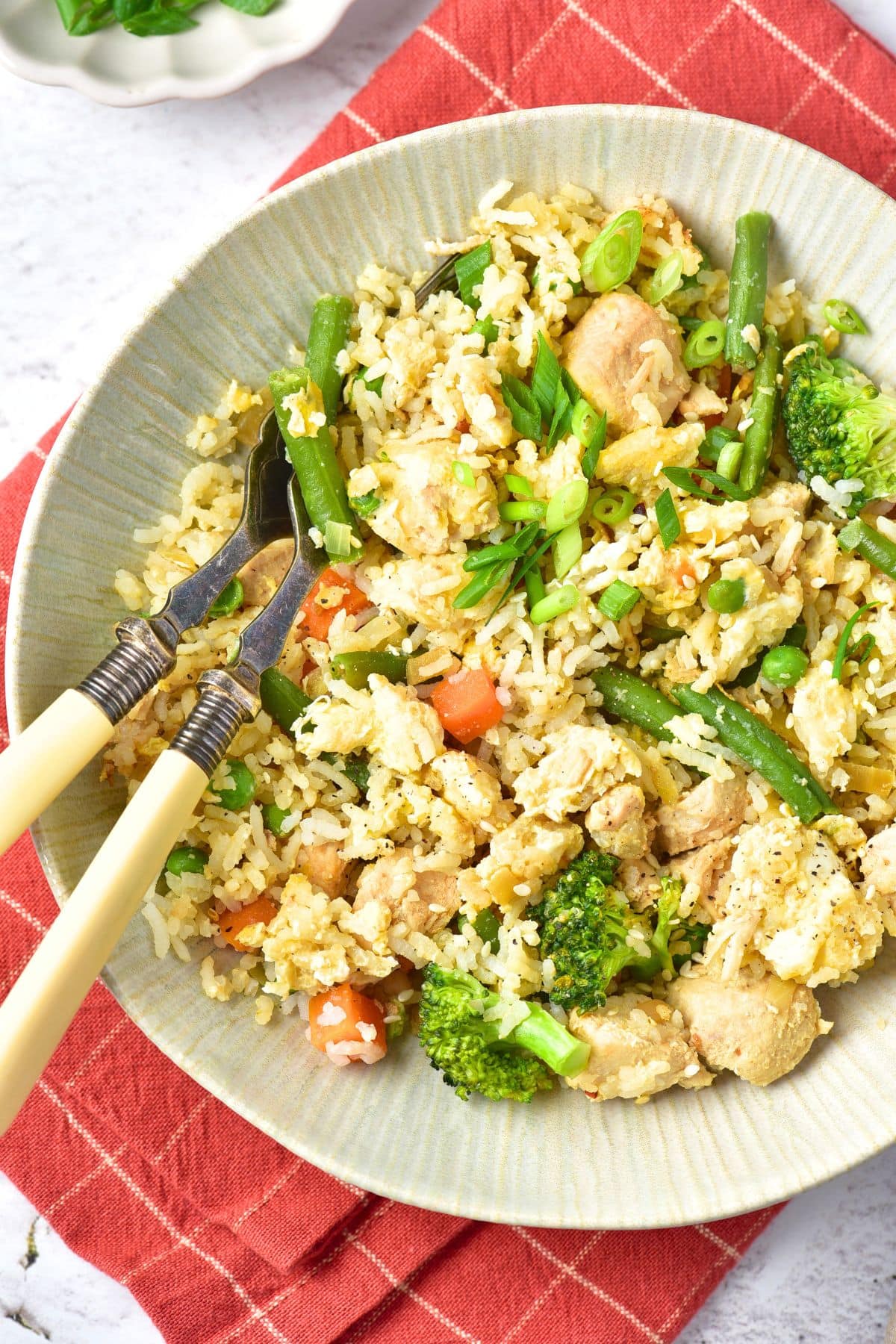 A bowl of turkey fried rice on red kitchen towel.