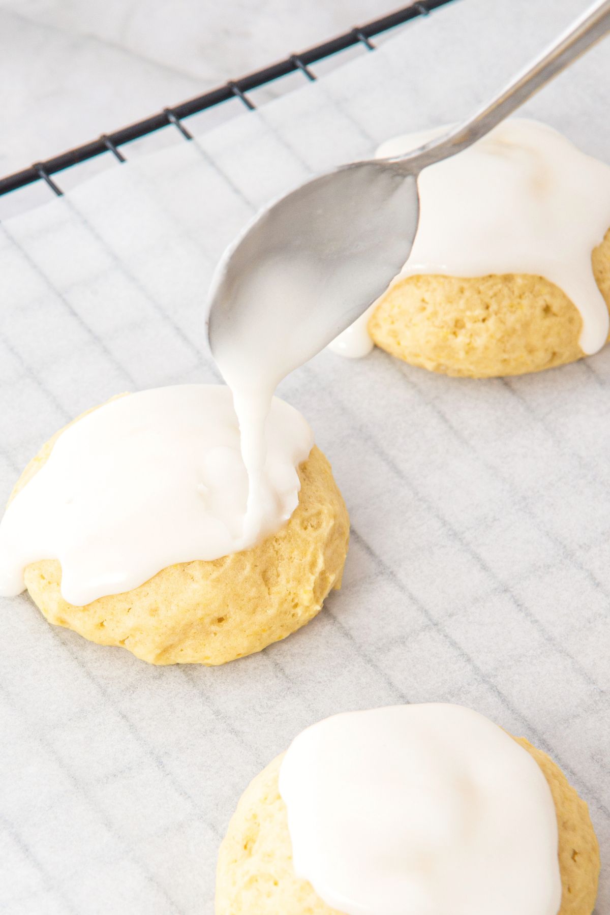 Drizzling lemon icing on parchment paper.