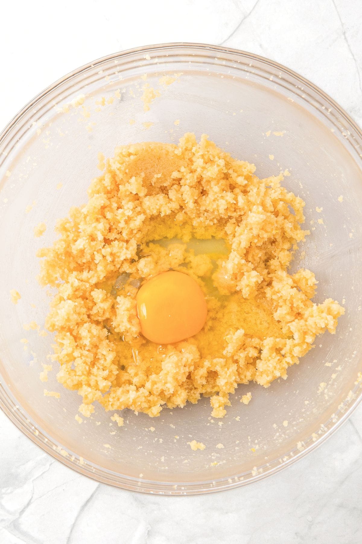 An egg and cookie dough in glass bowl
