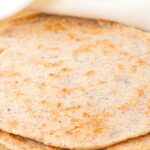 A stack of almond flour tortillas wrapped in a kitchen towel.
