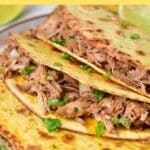 Pork carnitas tacos on a plate.
