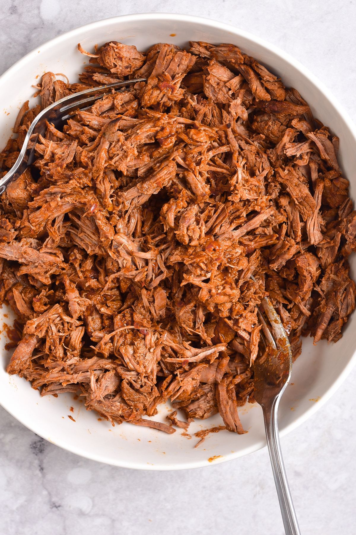 Shredding beef with two forks.