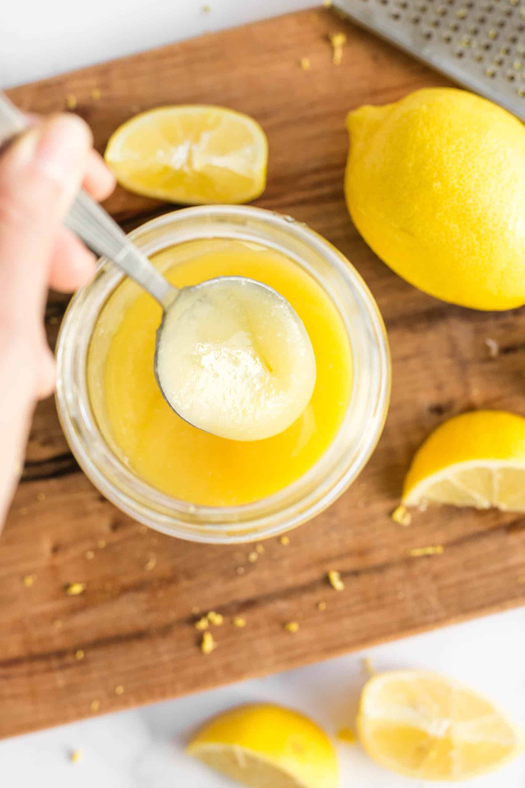 Scooping up a spoonful of freshly made lemon curd.