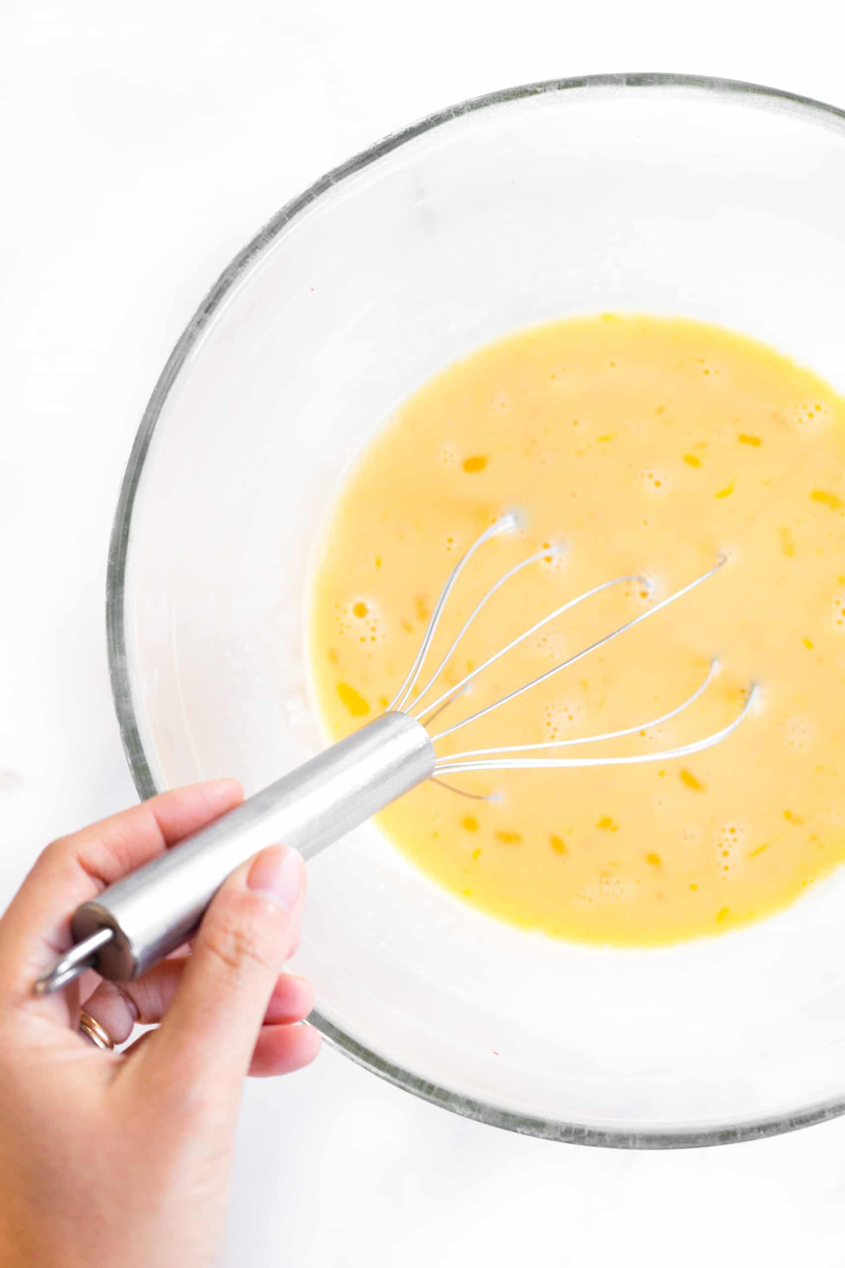 Whisking quiche batter in large mixing bowl.