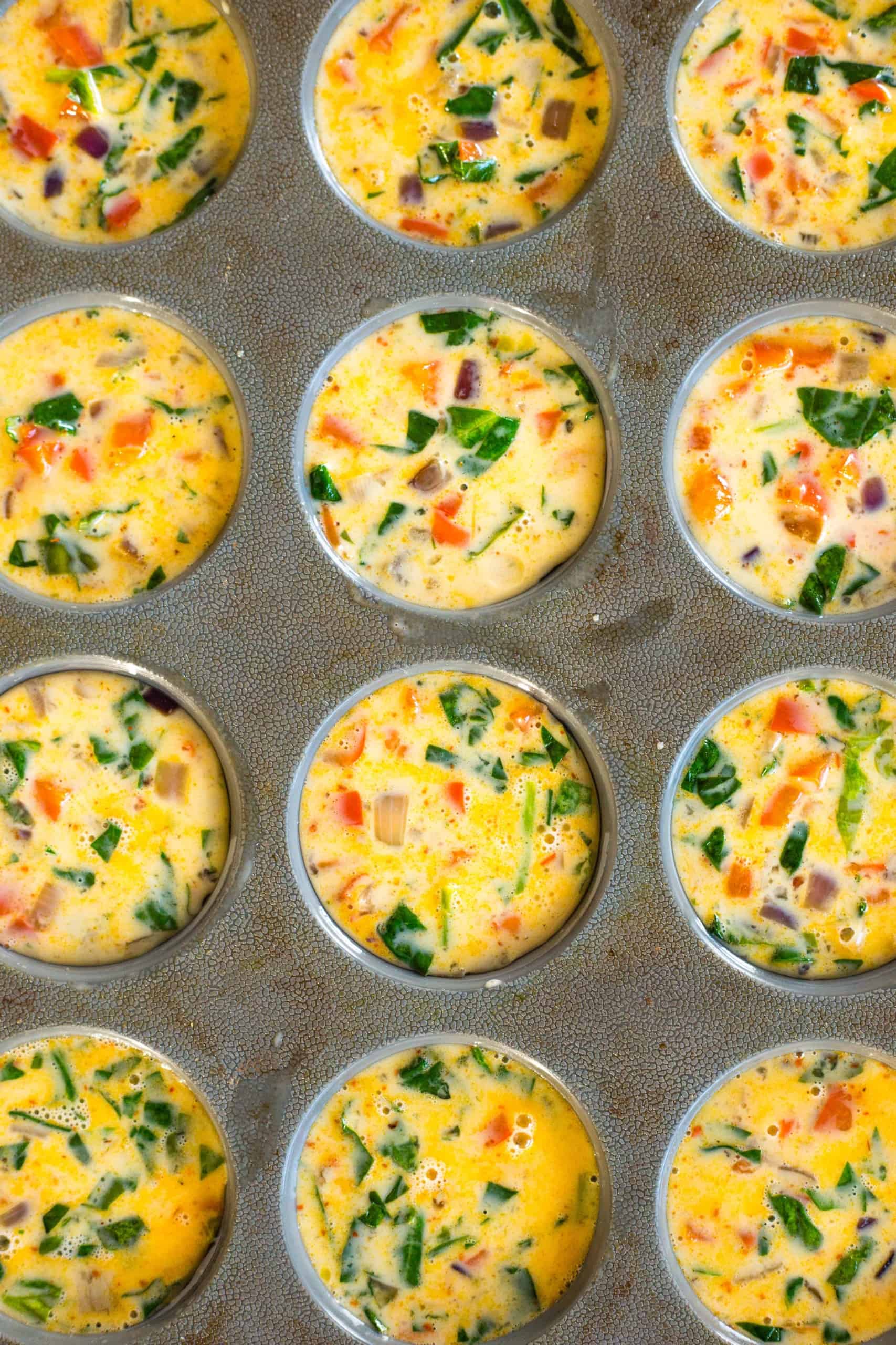 Uncooked quiche batter in silicon muffin mold.
