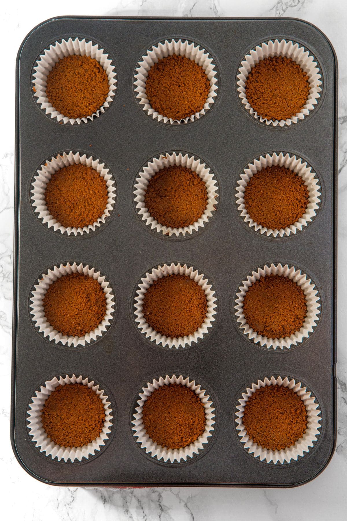 Graham cracker crumb base in muffin pan