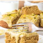Fork cutting into a square or pistachio cake