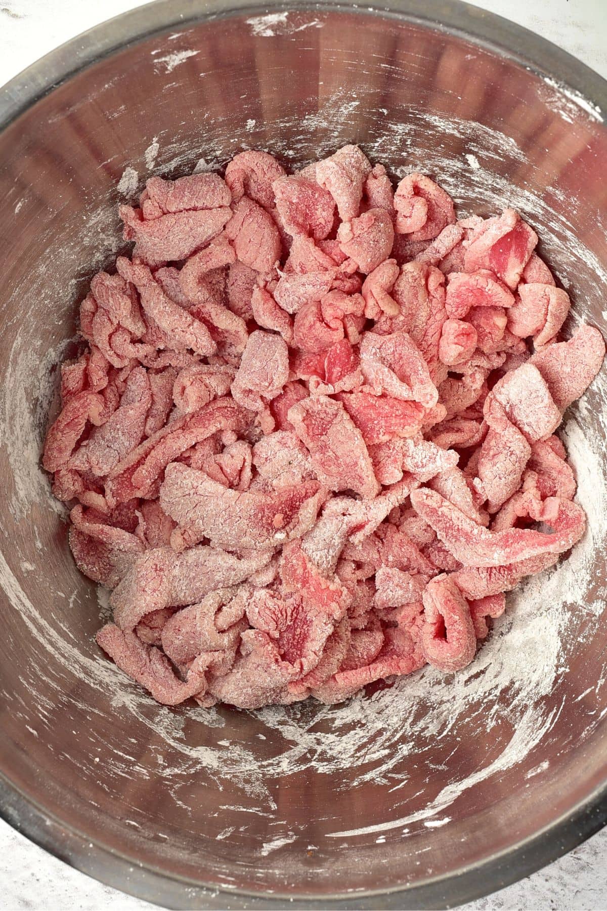 Tossing beef slices in cornstarch