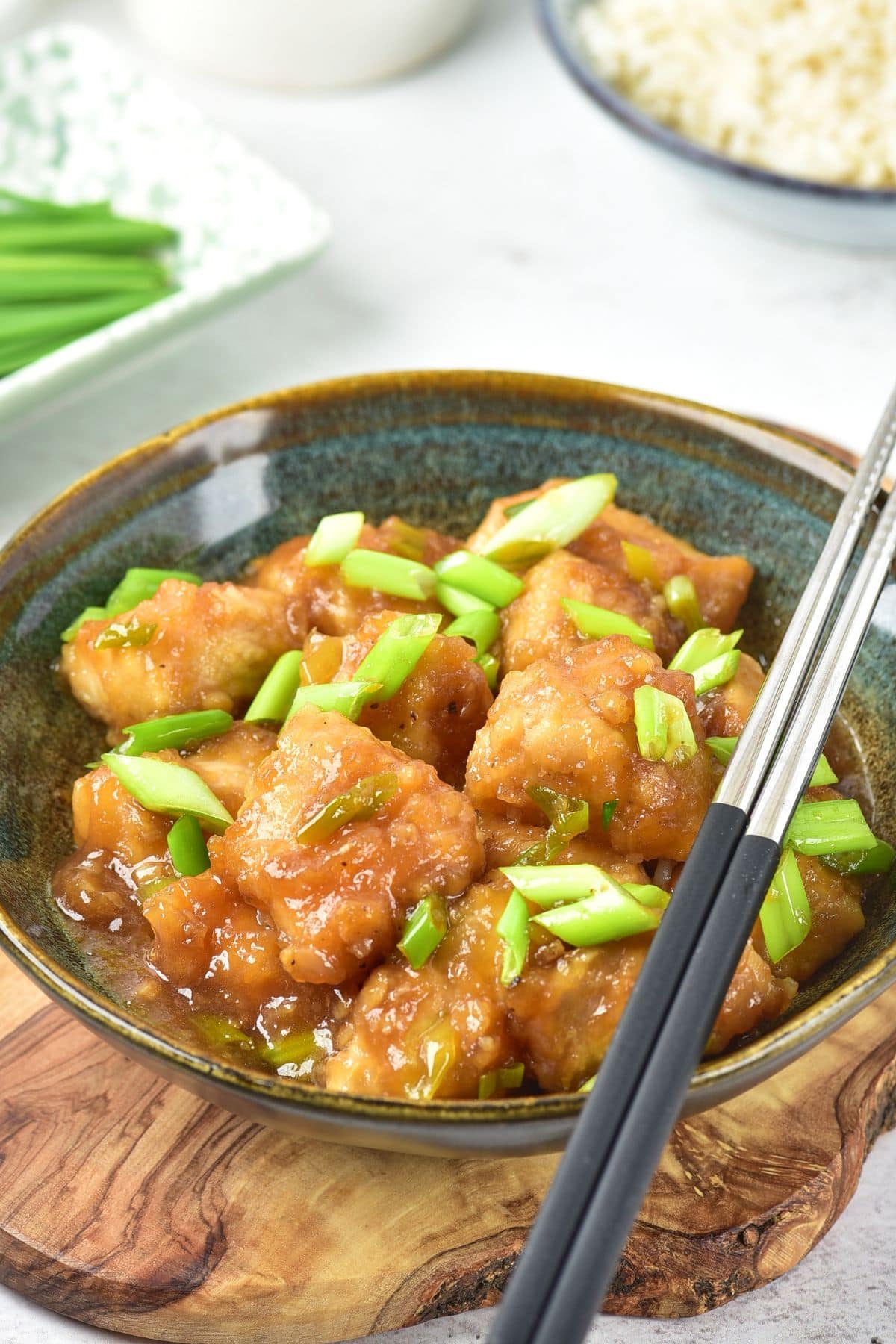 Up close view of chopsticks on a bowl of gluten-free Mongolian chicken