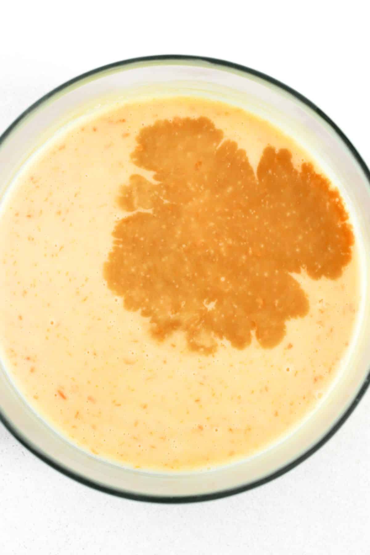 Vanilla extract and condensed milk in bowl.