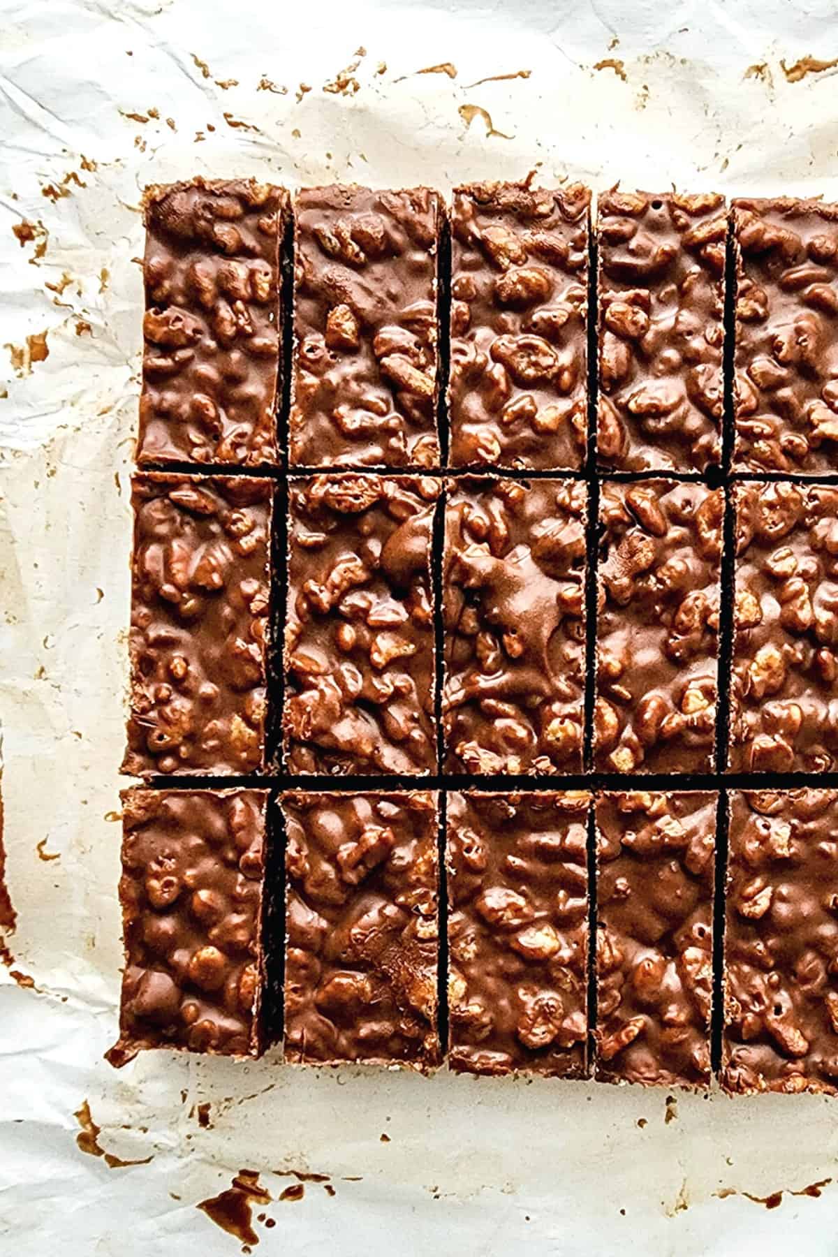 Sliced pieces of peanut butter crunch bars on parchment paper.