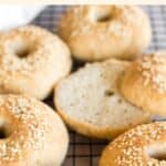 Half-sliced bagels on wire rack.