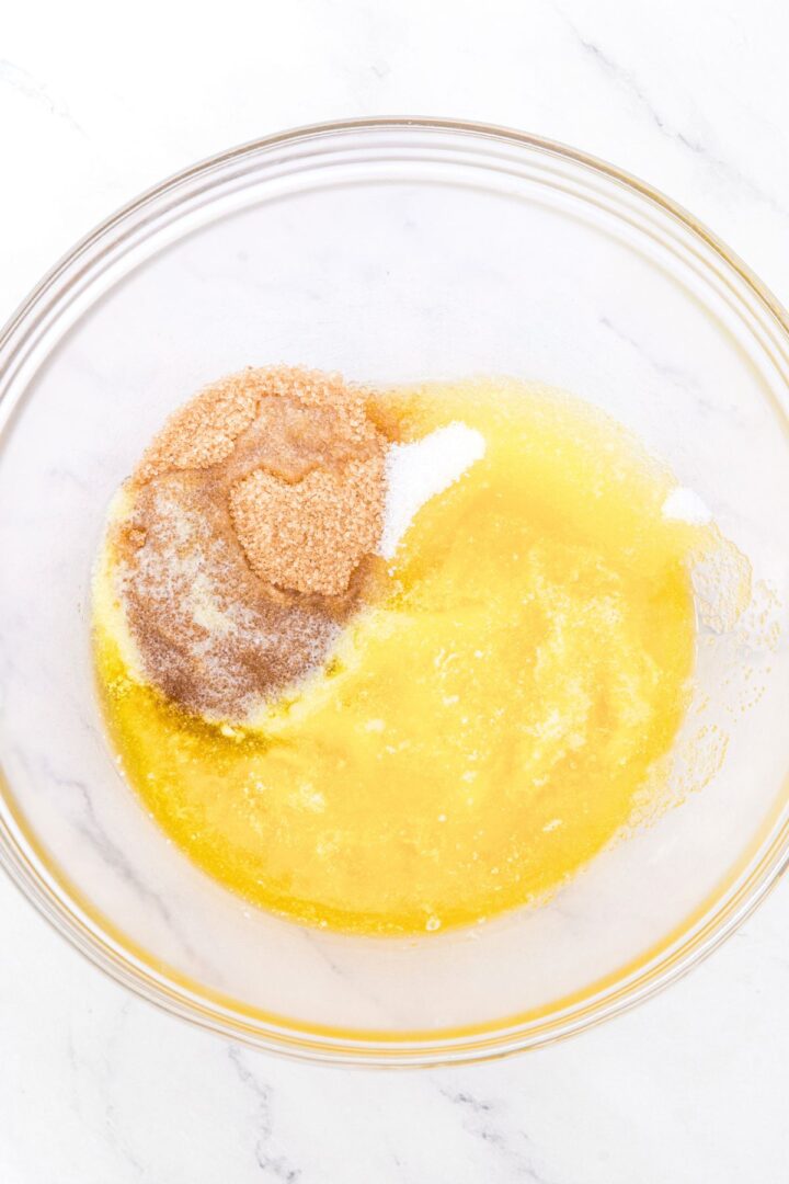 A bowl with melted butter, brown sugar and white sugar.