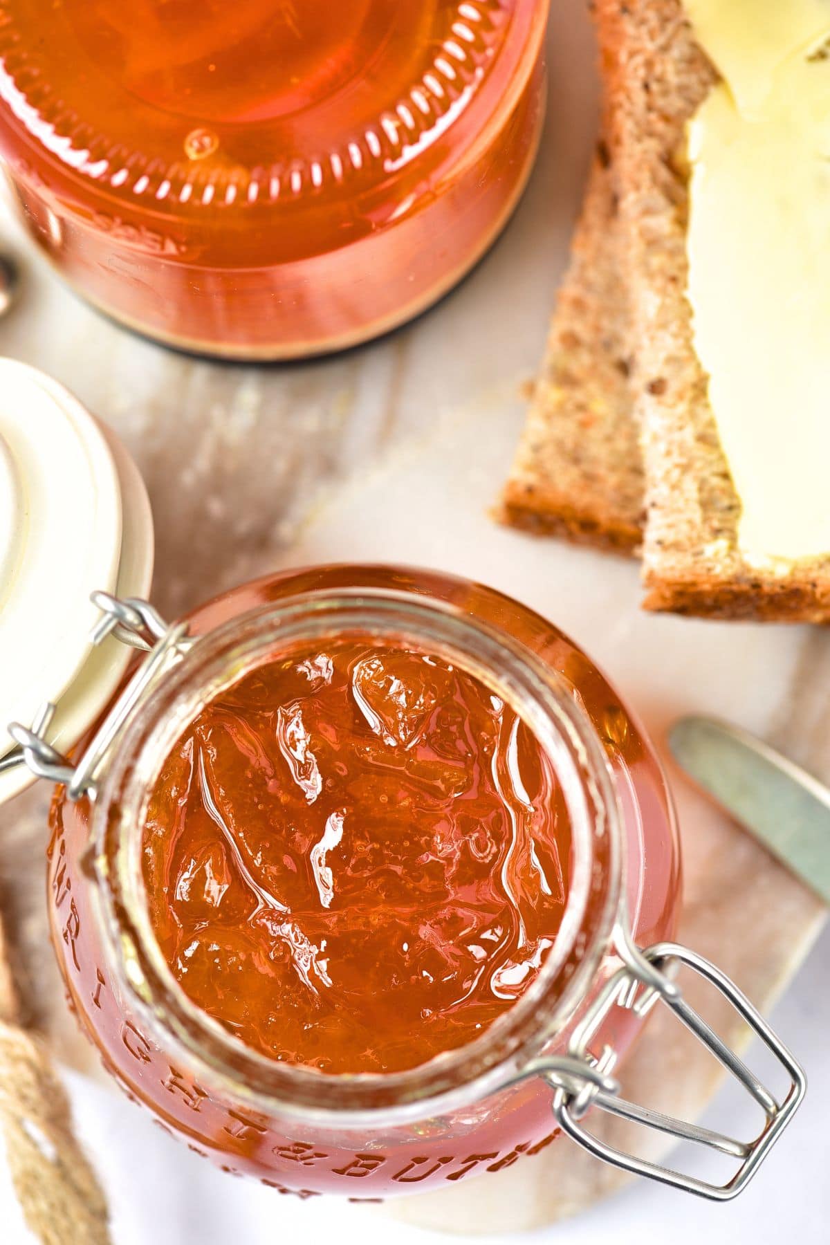 Top down view of an open jar of homemade orange marmalade.