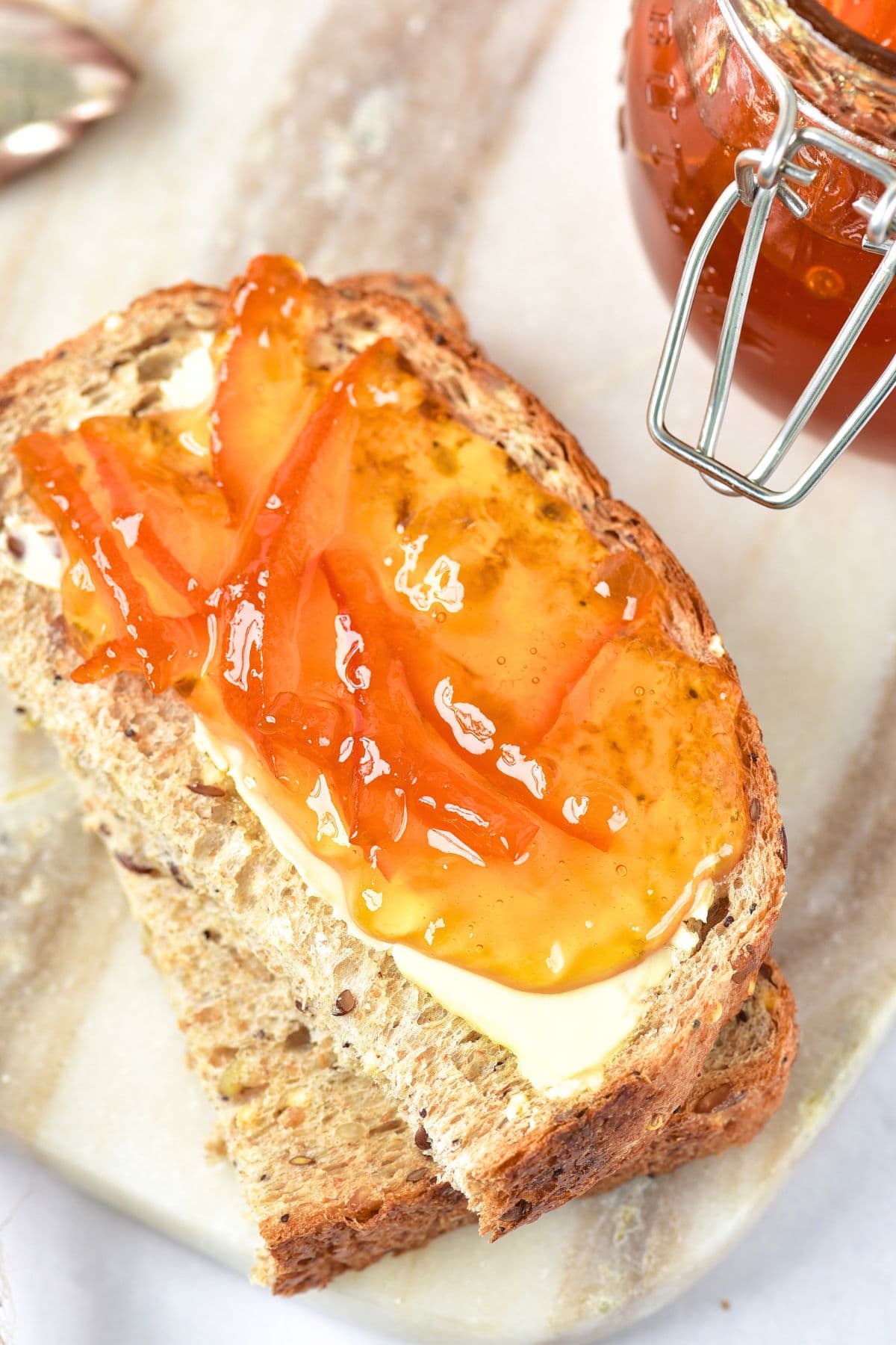 Orange marmalade spread on bread slices.