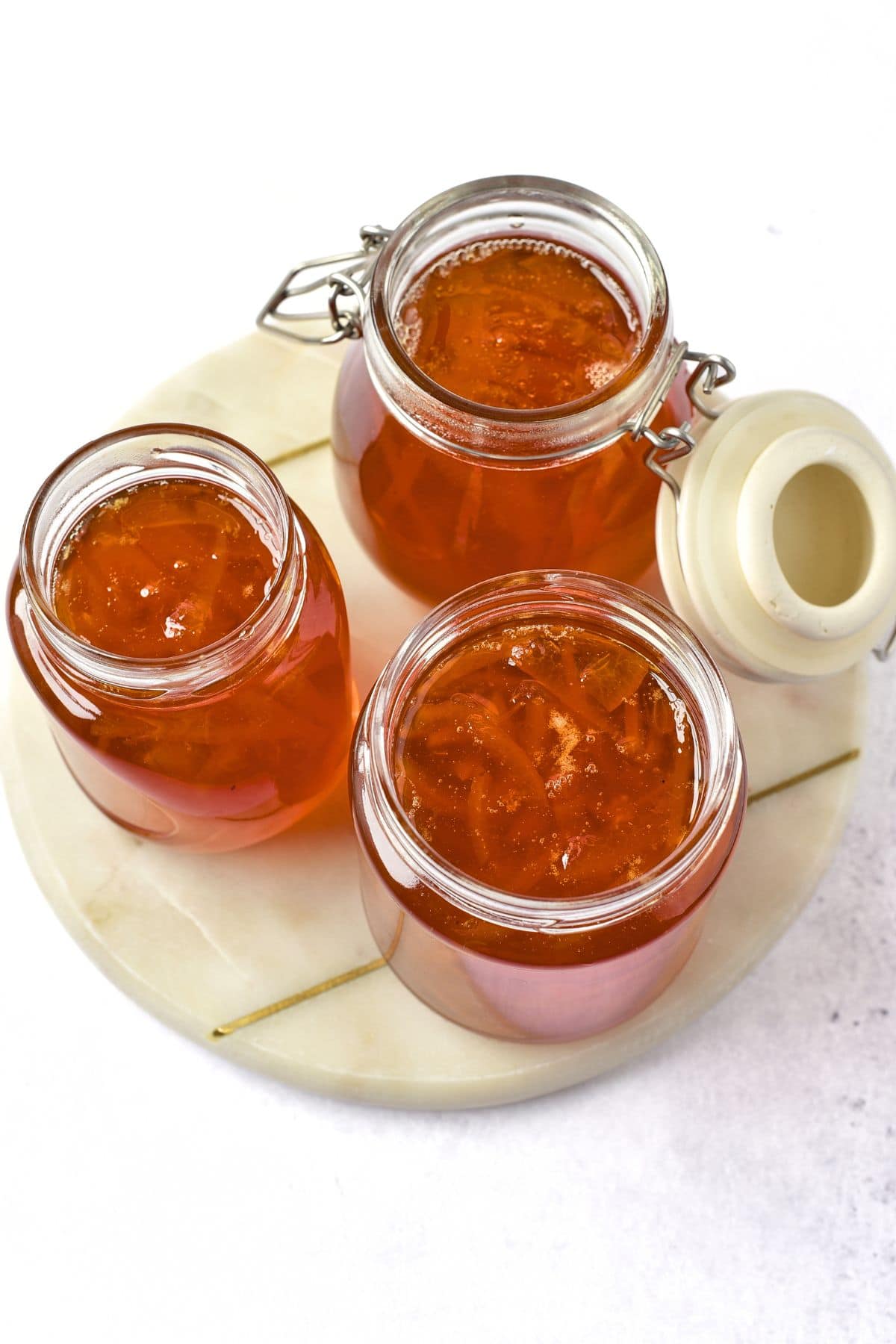 Jars of orange marmalade on marble board