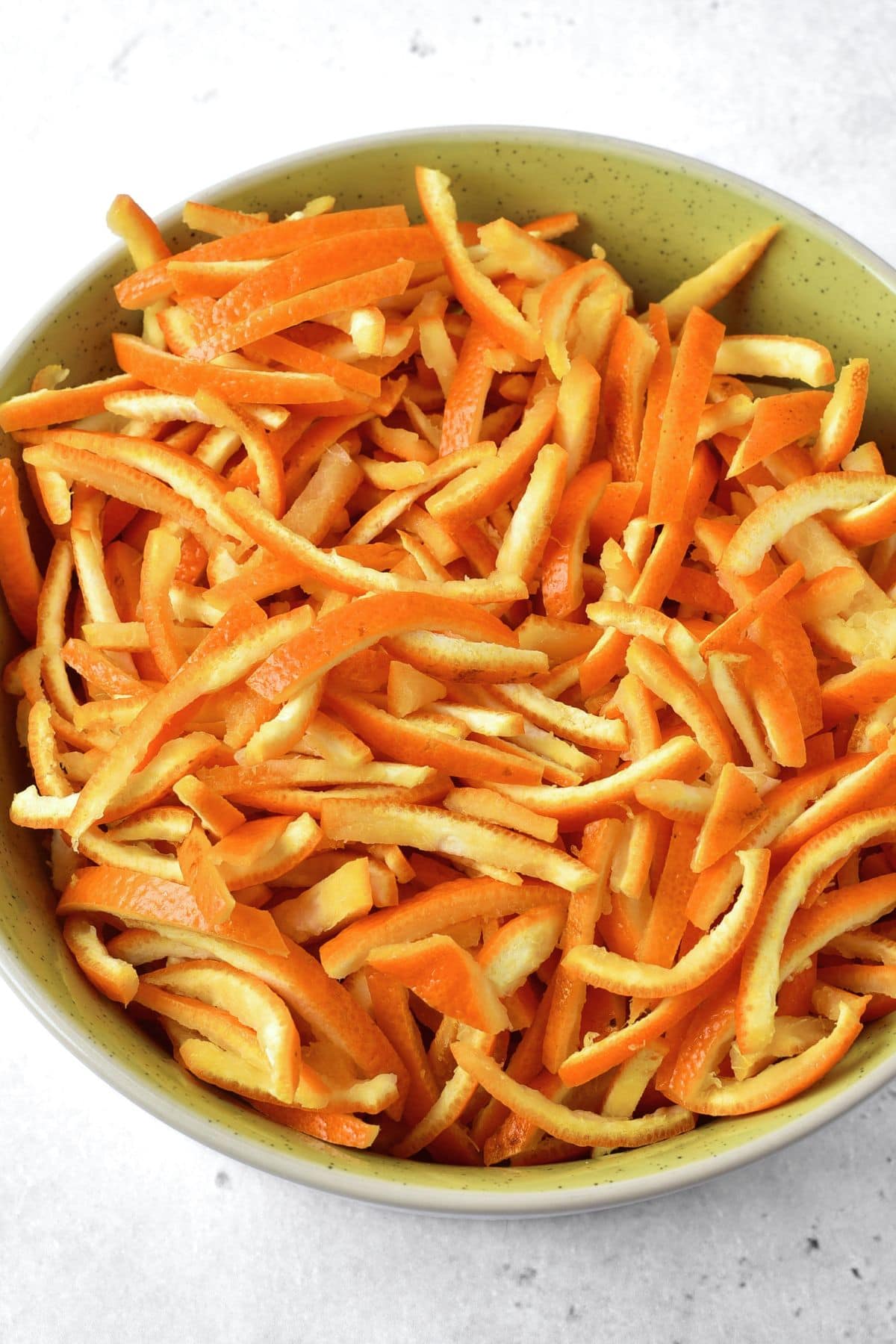 Thin orange peel slices in a bowl.