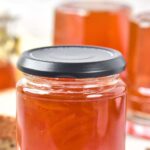 Close up view of a jar of orange marmalade.