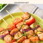 Up close view of four salmon kebabs on a plate.